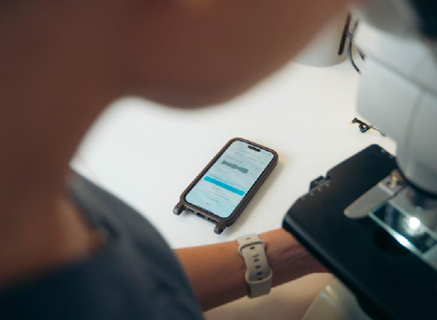 CoVet open on a phone beside a microscope in a clinic lab
